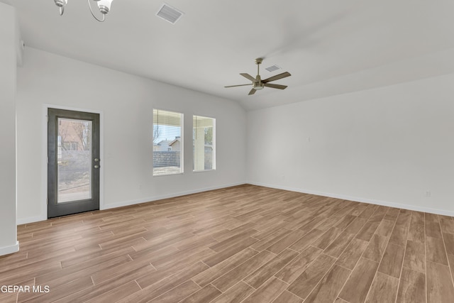 unfurnished room with ceiling fan with notable chandelier and lofted ceiling