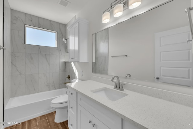 full bathroom featuring vanity, toilet, and tiled shower / bath