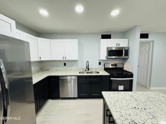 kitchen with white cabinets, light stone countertops, sink, and appliances with stainless steel finishes