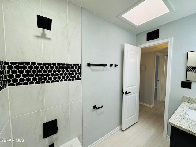 bathroom featuring a shower, vanity, and hardwood / wood-style flooring