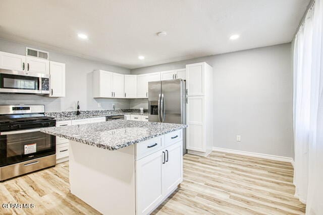 kitchen featuring white cabinets, appliances with stainless steel finishes, and a kitchen island