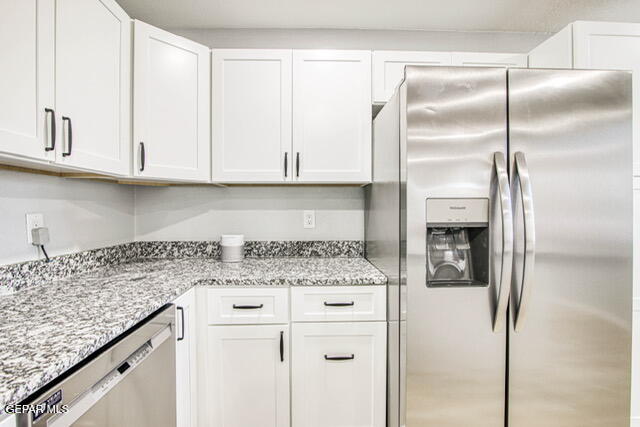 kitchen featuring white cabinets, light stone counters, and stainless steel appliances