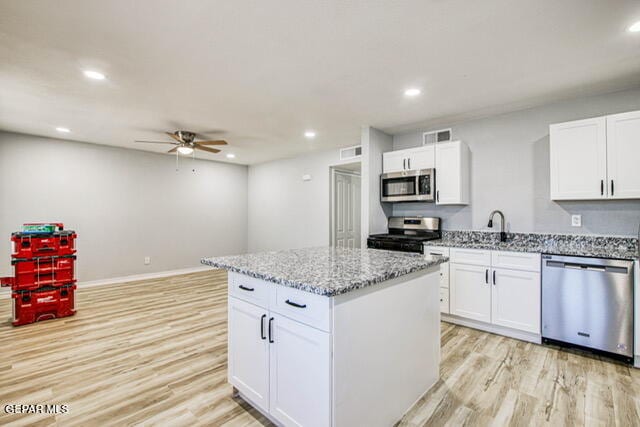 kitchen featuring a kitchen island, white cabinetry, and appliances with stainless steel finishes