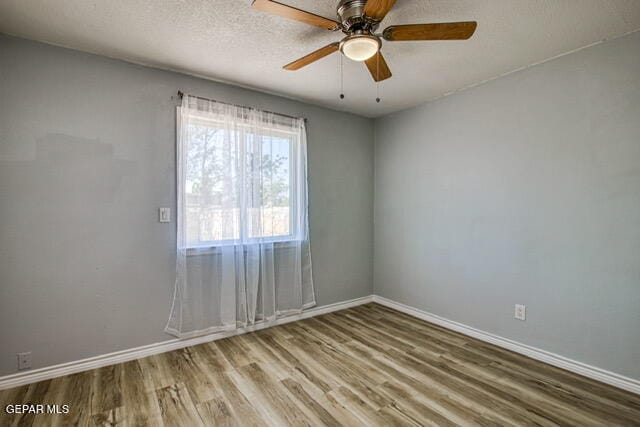 spare room with ceiling fan and wood-type flooring