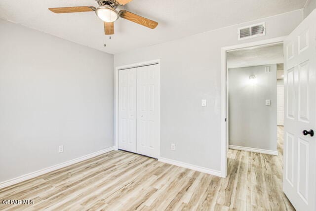 unfurnished bedroom with a closet, light hardwood / wood-style flooring, and ceiling fan