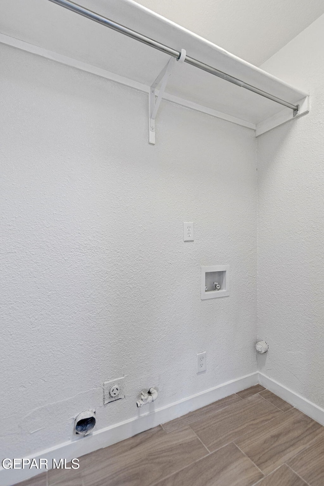 clothes washing area with gas dryer hookup, washer hookup, and hardwood / wood-style flooring