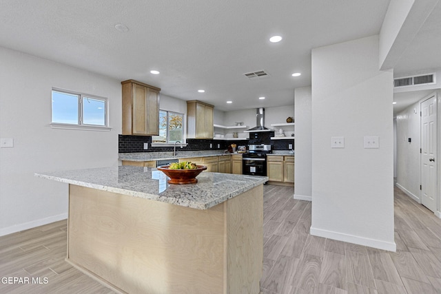 kitchen with light brown cabinets, wall chimney range hood, stainless steel range with electric cooktop, and tasteful backsplash