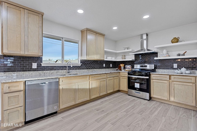 kitchen featuring light brown cabinets, sink, wall chimney exhaust hood, light stone countertops, and appliances with stainless steel finishes