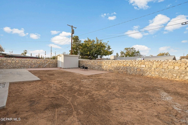 view of yard featuring a patio and a storage shed