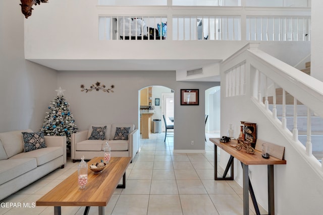 tiled living room featuring a towering ceiling