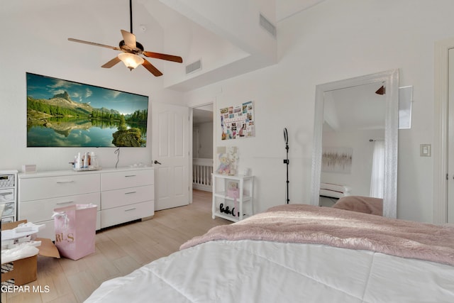 bedroom featuring ceiling fan, light hardwood / wood-style flooring, and high vaulted ceiling