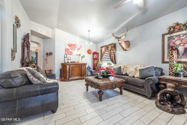 living room with ceiling fan with notable chandelier