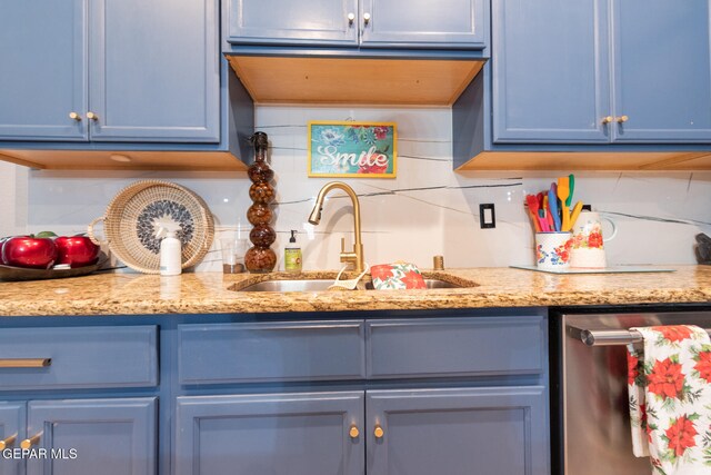 kitchen with sink, tasteful backsplash, light stone counters, stainless steel dishwasher, and blue cabinets