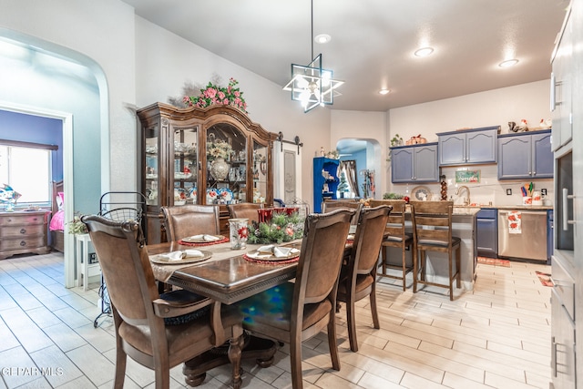 dining room featuring light hardwood / wood-style flooring, an inviting chandelier, and sink