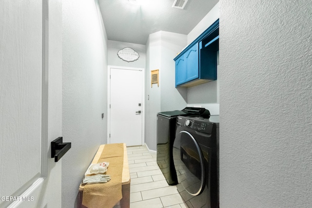 washroom with washer and dryer, cabinets, and light tile patterned floors