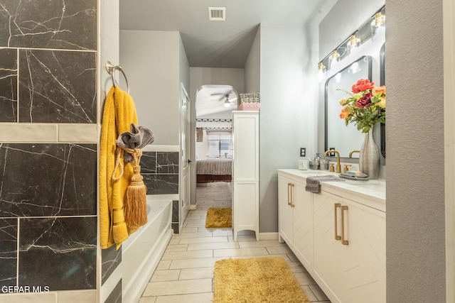 bathroom featuring vanity and a washtub