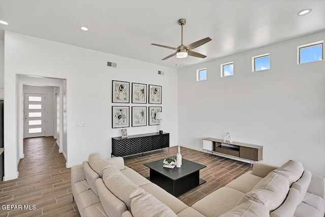 living room with ceiling fan and dark wood-type flooring