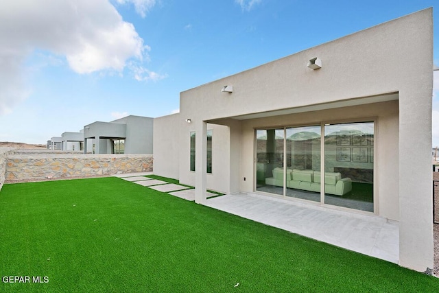 rear view of property with a lawn and a patio