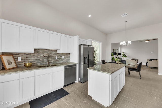 kitchen featuring sink, a center island, hanging light fixtures, stainless steel appliances, and white cabinets