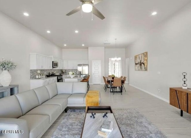 living room featuring ceiling fan with notable chandelier