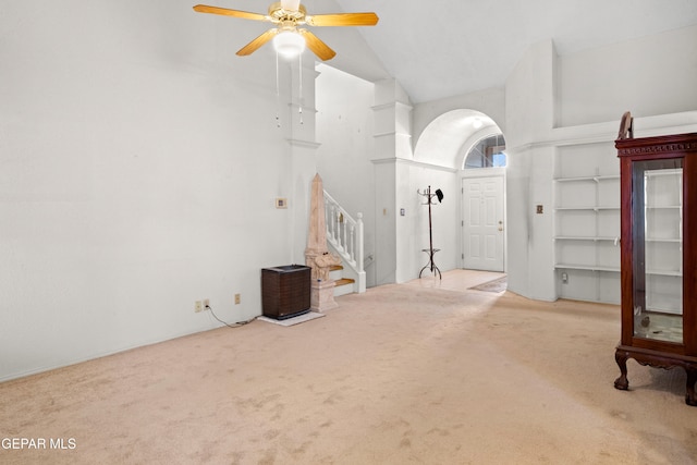 foyer entrance featuring carpet flooring, high vaulted ceiling, and ceiling fan