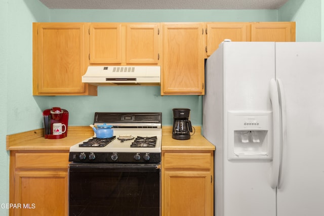 kitchen with light brown cabinets, white appliances, and a textured ceiling