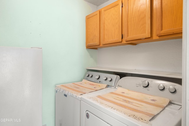 laundry area featuring cabinets and washing machine and clothes dryer