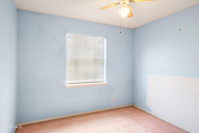 spare room with a textured ceiling and ceiling fan