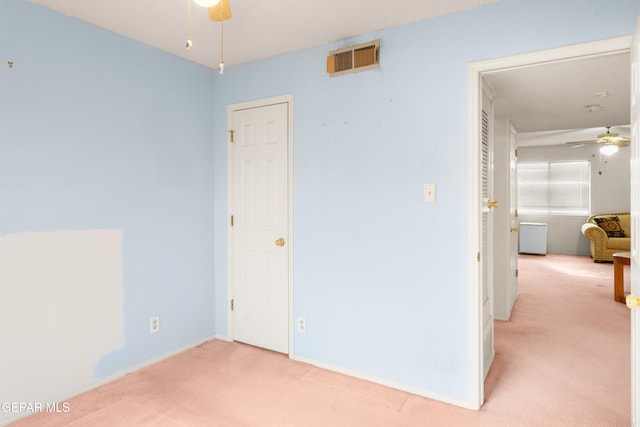 unfurnished room featuring light carpet and ceiling fan