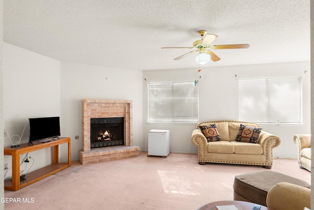 carpeted living room with ceiling fan, a textured ceiling, and a brick fireplace