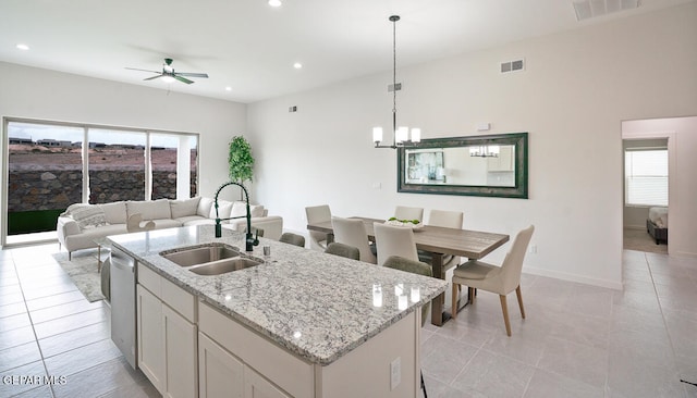 kitchen featuring pendant lighting, dishwasher, sink, white cabinets, and a kitchen island with sink