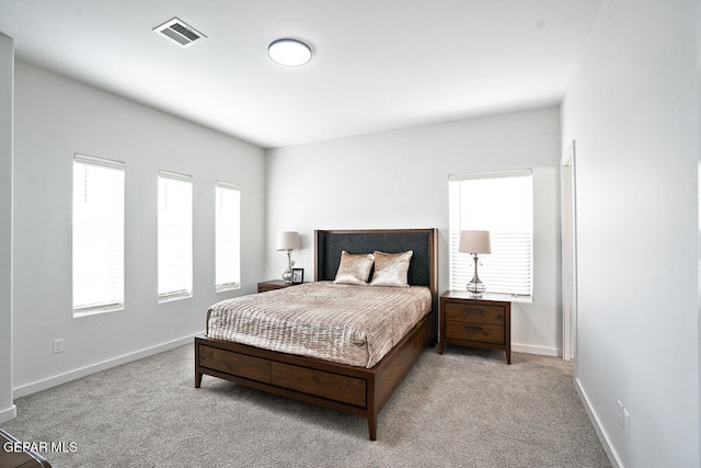 bedroom featuring multiple windows and light colored carpet