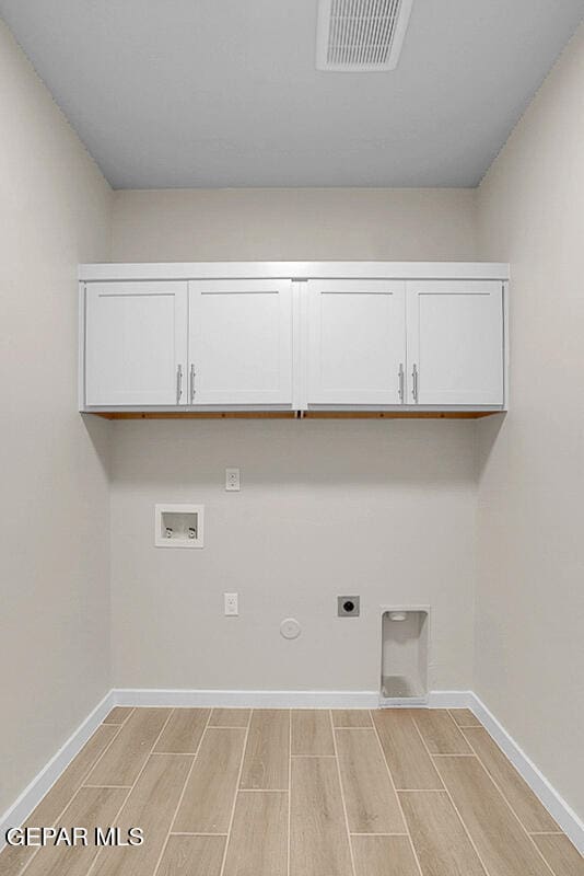 clothes washing area featuring gas dryer hookup, hookup for a washing machine, cabinets, and hookup for an electric dryer