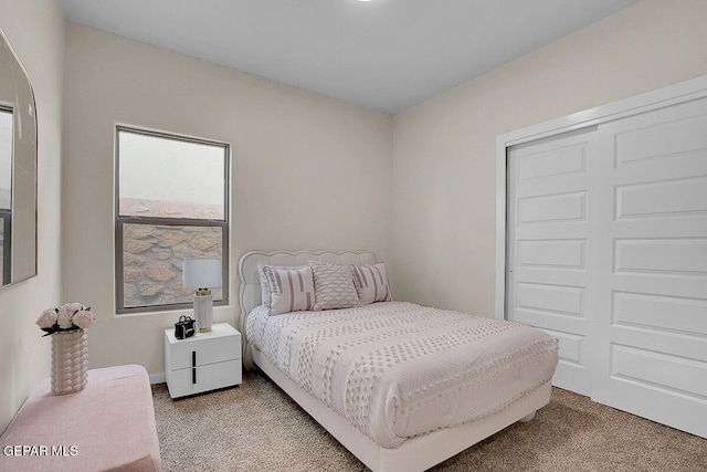 bedroom with a closet and light carpet