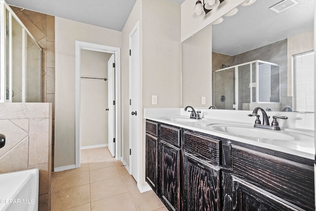 full bathroom featuring double vanity, tile patterned flooring, visible vents, and a sink