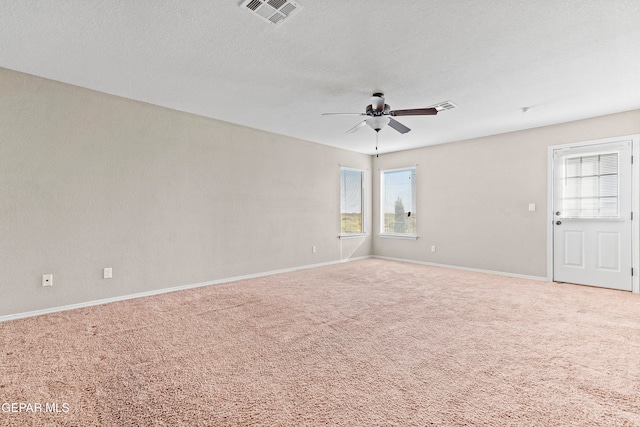 spare room with visible vents, carpet flooring, ceiling fan, a textured ceiling, and baseboards