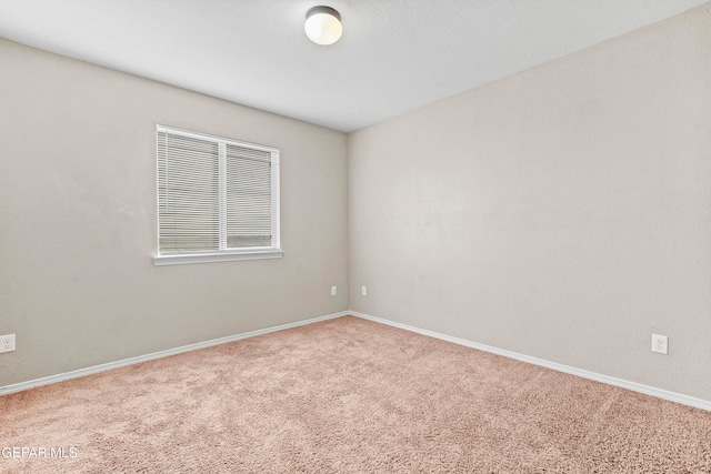 carpeted spare room featuring baseboards