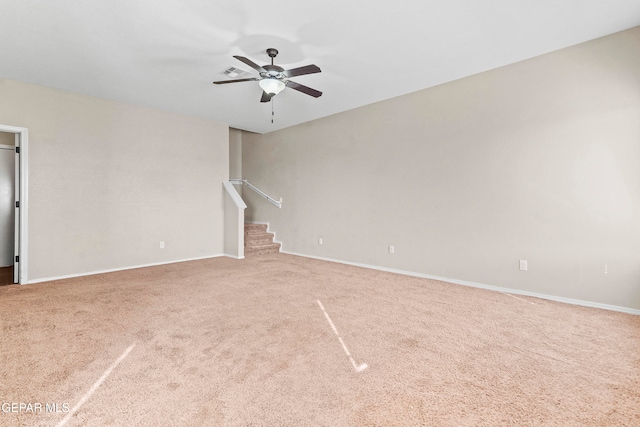 unfurnished living room featuring carpet, ceiling fan, stairs, and baseboards