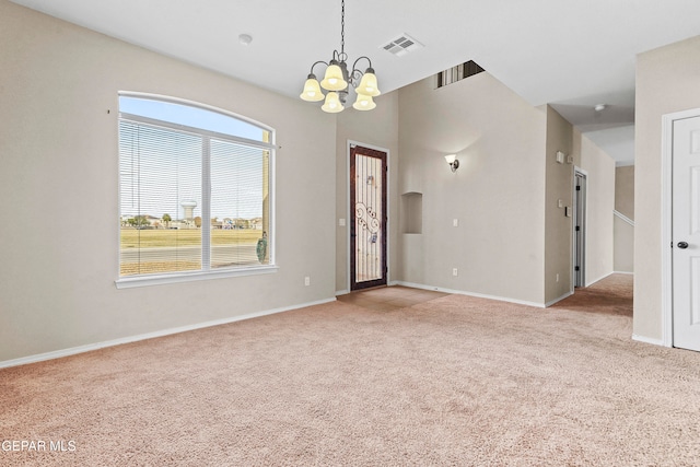 unfurnished room with light carpet, baseboards, visible vents, and a notable chandelier