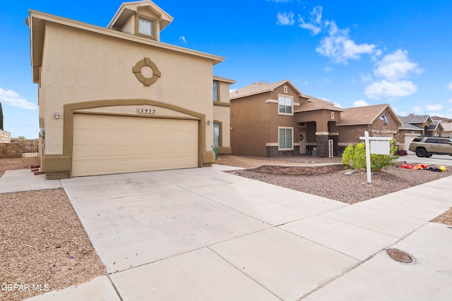 view of front of house featuring driveway, a garage, and stucco siding