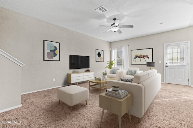 living area featuring ceiling fan, carpet, and a healthy amount of sunlight