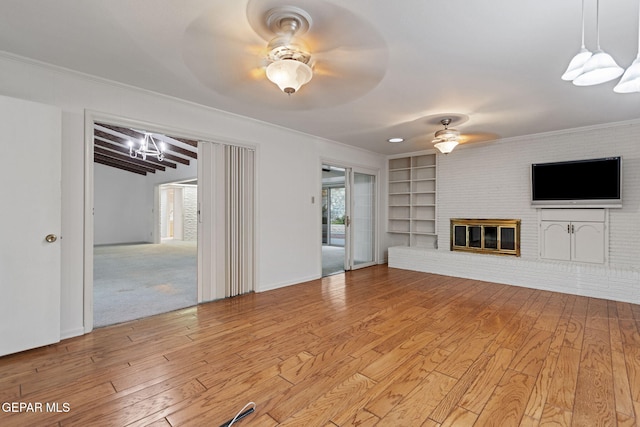 unfurnished living room with a fireplace, light colored carpet, ceiling fan, and crown molding