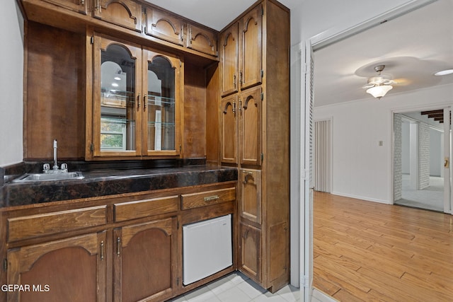 kitchen with light wood-type flooring, ceiling fan, and sink