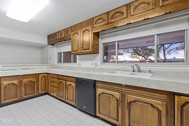 kitchen with sink, light tile patterned floors, and black dishwasher