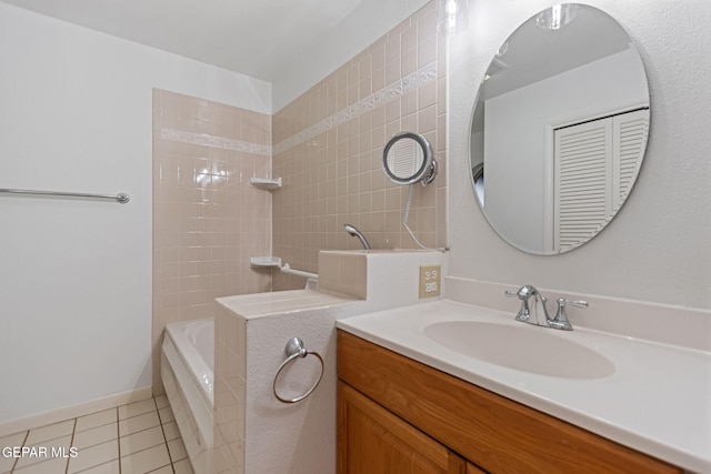 bathroom with tile patterned flooring, vanity, and tiled shower / bath