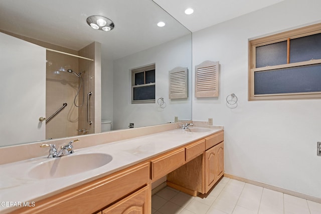 bathroom featuring tiled shower, tile patterned floors, vanity, and toilet