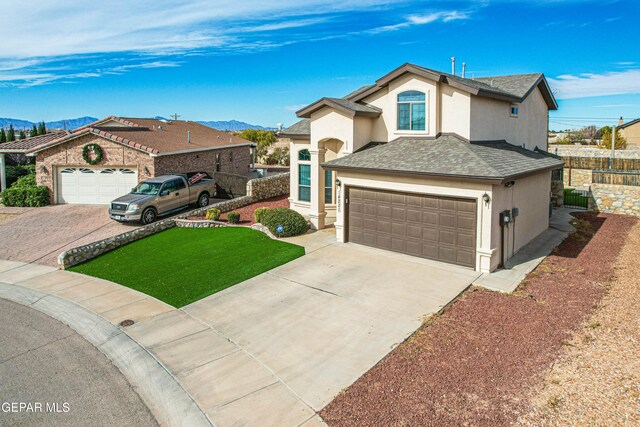 view of front facade with a mountain view, a garage, and a front yard