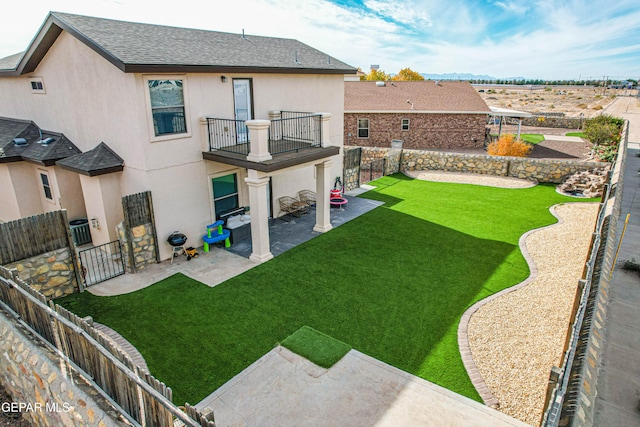 view of yard featuring a patio area, a balcony, and central AC