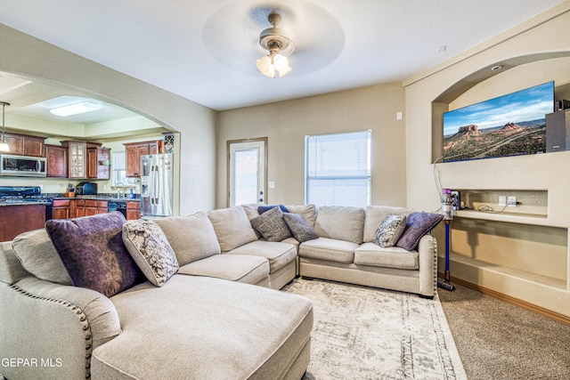 carpeted living room featuring ceiling fan