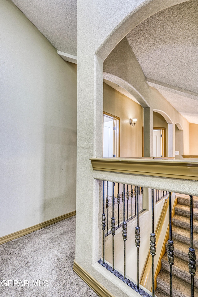 corridor featuring carpet flooring and a textured ceiling